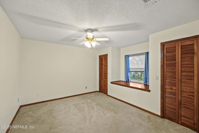 521 Birch Ct, Neptune Beach, FL 32266 - unfurnished bedroom with carpet flooring, a ceiling fan, multiple closets, and a textured ceiling