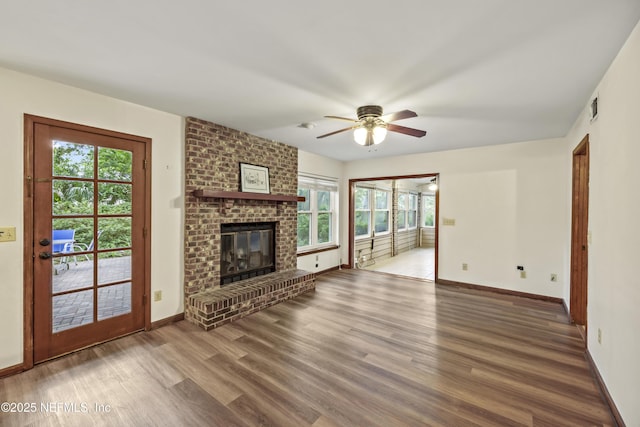 521 Birch Ct, Neptune Beach, FL 32266 - unfurnished living room with ceiling fan, wood finished floors, a fireplace, and healthy amount of natural light