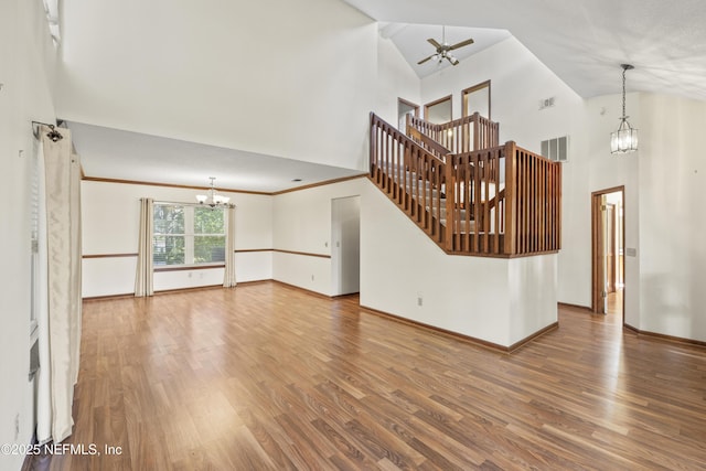 521 Birch Ct, Neptune Beach, FL 32266 - unfurnished living room with a chandelier, ceiling fan, high vaulted ceiling, wood finished floors, and stairs