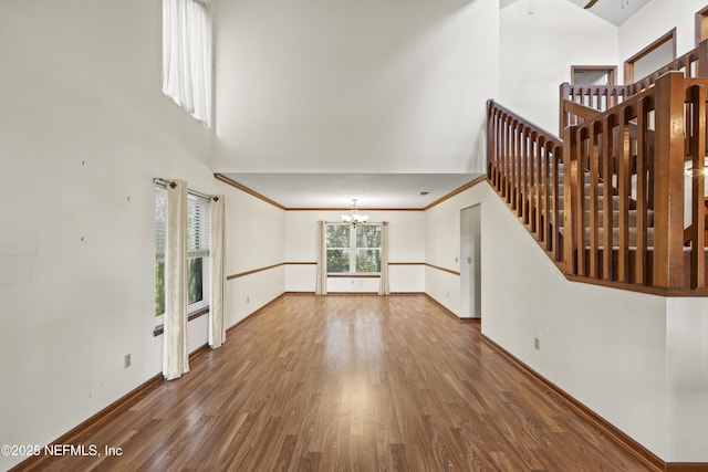 521 Birch Ct, Neptune Beach, FL 32266 - unfurnished living room featuring a chandelier, wood finished floors, and a towering ceiling