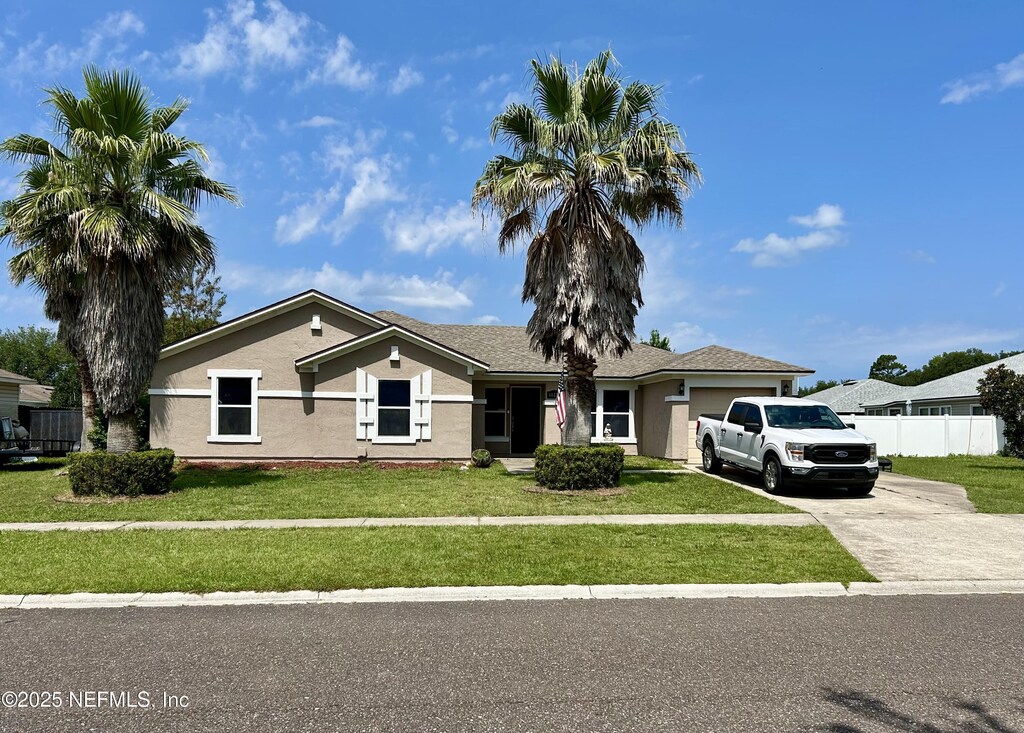 86111 Cartesian Pointe Dr, Yulee, FL 32097 - ranch-style home with driveway, an attached garage, and stucco siding