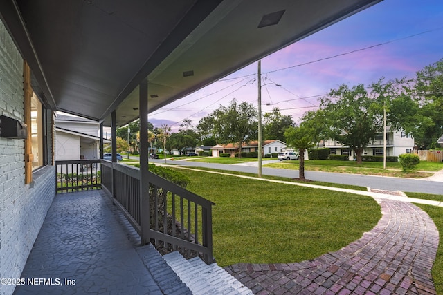1900 Dalamon St, Jacksonville, FL 32211 - deck at dusk featuring covered porch and a yard