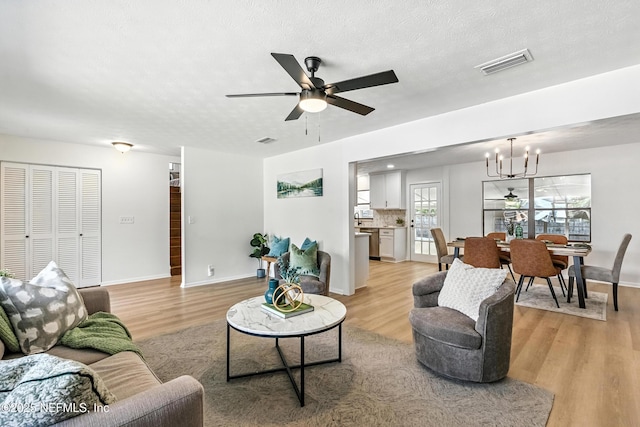 1900 Dalamon St, Jacksonville, FL 32211 - living area featuring light wood-style floors, ceiling fan, and a chandelier