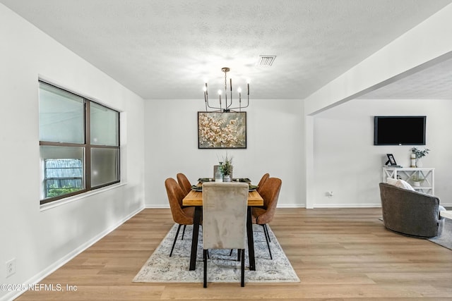 1900 Dalamon St, Jacksonville, FL 32211 - dining space with a chandelier, light wood-style floors, and a textured ceiling