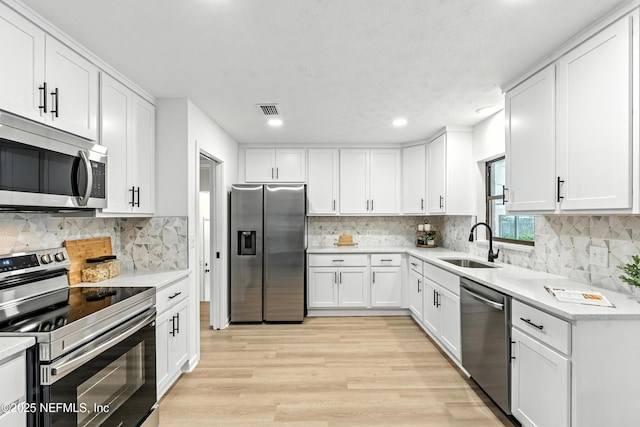 1900 Dalamon St, Jacksonville, FL 32211 - kitchen with stainless steel appliances, light wood finished floors, white cabinets, and recessed lighting