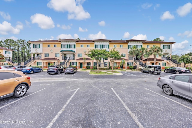 9745 Touchton Rd Unit 121, Jacksonville, FL 32246 - view of property with uncovered parking, a residential view, and stairs