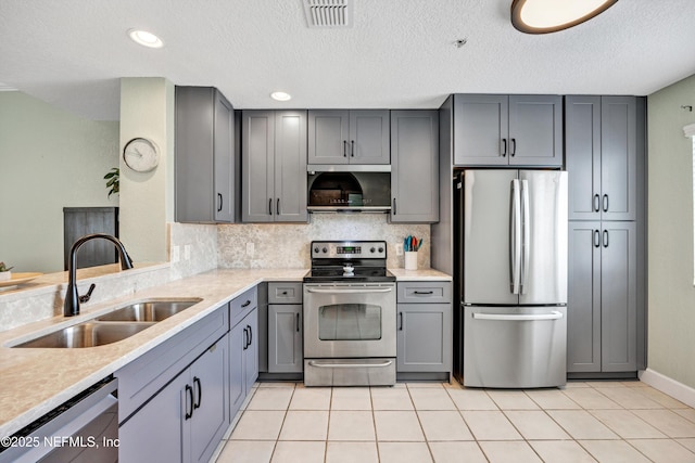 9745 Touchton Rd Unit 121, Jacksonville, FL 32246 - kitchen with stainless steel appliances, gray cabinets, light countertops, backsplash, and light tile patterned floors