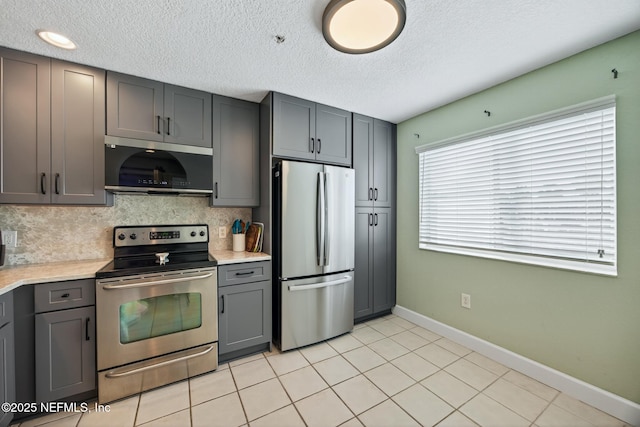 9745 Touchton Rd Unit 121, Jacksonville, FL 32246 - kitchen featuring appliances with stainless steel finishes, gray cabinetry, light countertops, decorative backsplash, and a textured ceiling