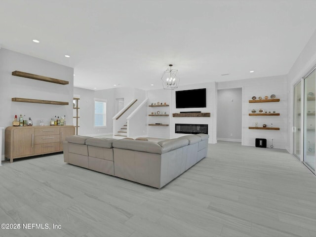 32 Awlleaf Ct, Saint Augustine, FL 32095 - living area featuring stairway, a glass covered fireplace, a chandelier, recessed lighting, and a dry bar