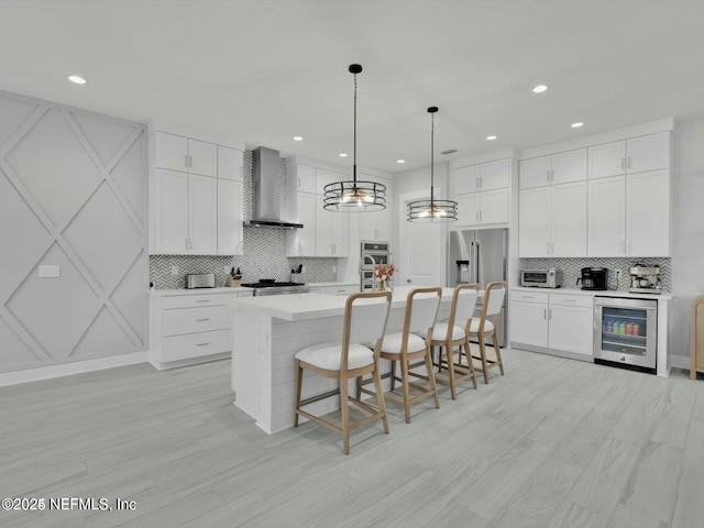 32 Awlleaf Ct, Saint Augustine, FL 32095 - kitchen with wall chimney range hood, appliances with stainless steel finishes, beverage cooler, decorative backsplash, and a kitchen bar