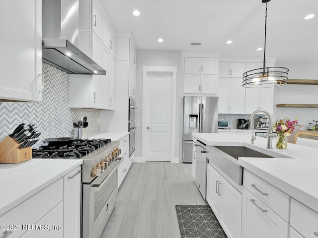 32 Awlleaf Ct, Saint Augustine, FL 32095 - kitchen featuring wall chimney range hood, appliances with stainless steel finishes, light countertops, white cabinetry, and recessed lighting