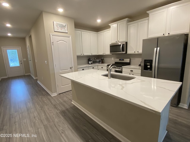 66 Tree Frog Way, Saint Augustine, FL 32095 - kitchen featuring appliances with stainless steel finishes, white cabinets, dark wood finished floors, light stone countertops, and recessed lighting