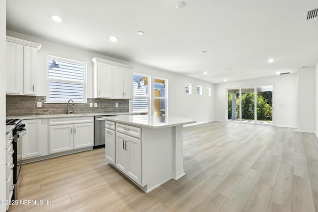 81 Glenhurst Ave, Ponte Vedra, FL 32081 - kitchen with stainless steel appliances, open floor plan, light wood-style flooring, light countertops, and tasteful backsplash