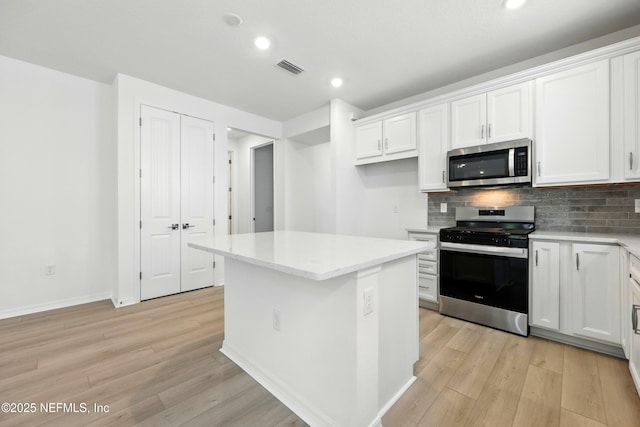 81 Glenhurst Ave, Ponte Vedra, FL 32081 - kitchen with stainless steel appliances, light wood-style floors, white cabinets, tasteful backsplash, and recessed lighting