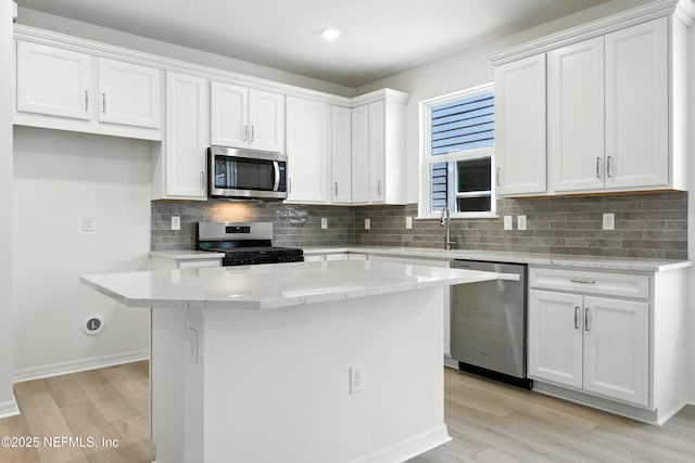 81 Glenhurst Ave, Ponte Vedra, FL 32081 - kitchen featuring stainless steel appliances, light wood-type flooring, white cabinets, a center island, and recessed lighting
