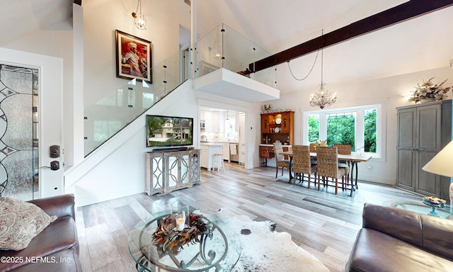 3793 Forest Dr, Middleburg, FL 32068 - living room with high vaulted ceiling, a chandelier, beamed ceiling, light wood-type flooring, and stairway
