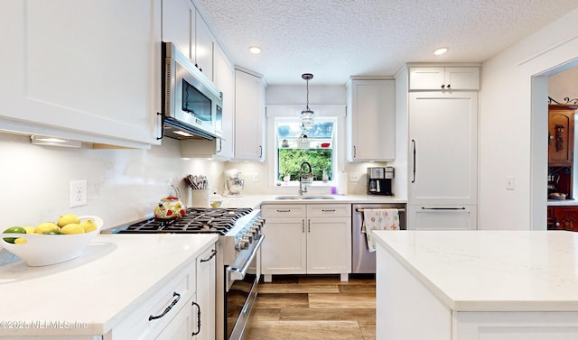 3793 Forest Dr, Middleburg, FL 32068 - kitchen featuring high quality appliances, light wood finished floors, decorative light fixtures, white cabinets, and recessed lighting