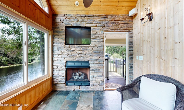 3793 Forest Dr, Middleburg, FL 32068 - living area featuring wooden walls, stone finish floors, an outdoor stone fireplace, a water view, and wood ceiling