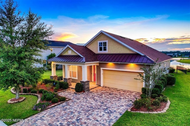 85212 Champlain Dr, Fernandina Beach, FL 32034 - craftsman house with a standing seam roof, covered porch, a front yard, decorative driveway, and a metal roof