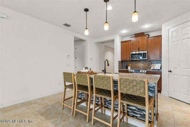 85212 Champlain Dr, Fernandina Beach, FL 32034 - kitchen featuring stainless steel appliances, decorative backsplash, light tile patterned floors, light stone counters, and recessed lighting