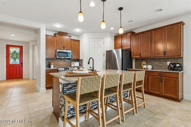 85212 Champlain Dr, Fernandina Beach, FL 32034 - kitchen featuring stainless steel appliances, recessed lighting, decorative backsplash, light stone counters, and brown cabinetry