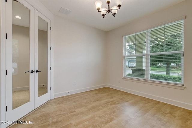 85212 Champlain Dr, Fernandina Beach, FL 32034 - empty room featuring a chandelier, healthy amount of natural light, light wood-style flooring, and french doors