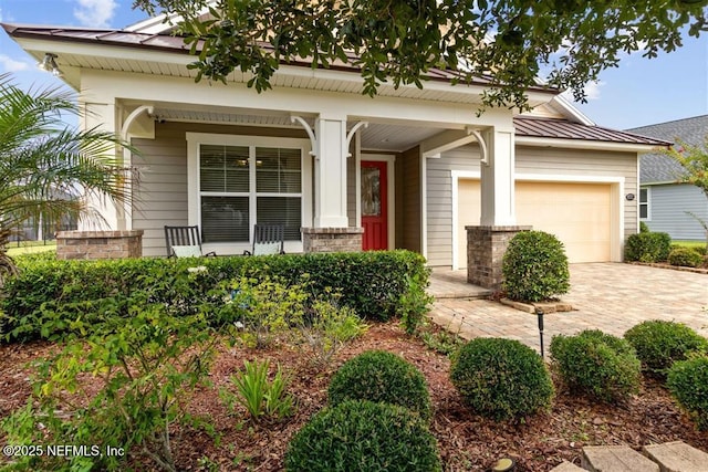 85212 Champlain Dr, Fernandina Beach, FL 32034 - view of front of property with a porch, a garage, decorative driveway, and a metal roof