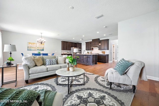 24 Tradesman Ln, Saint Johns, FL 32259 - living room featuring a chandelier, light wood-type flooring, recessed lighting, and a textured ceiling