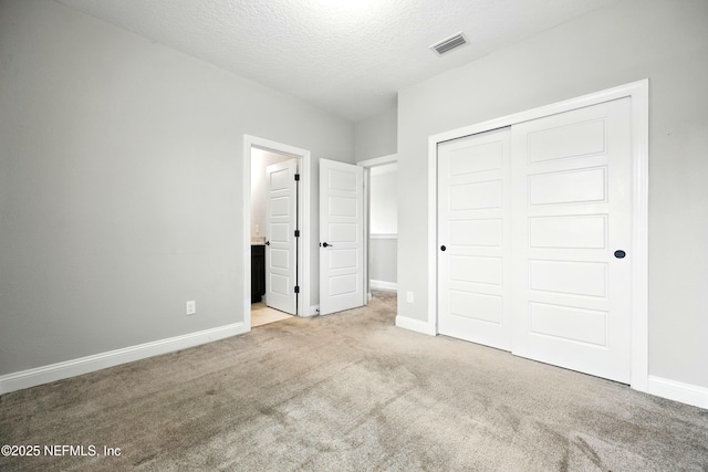 24 Tradesman Ln, Saint Johns, FL 32259 - unfurnished bedroom with carpet floors, a closet, a textured ceiling, and connected bathroom