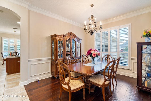 2025 Castle Point Ct, Fleming Island, FL 32003 - dining room with a chandelier, arched walkways, a decorative wall, hardwood / wood-style floors, and crown molding