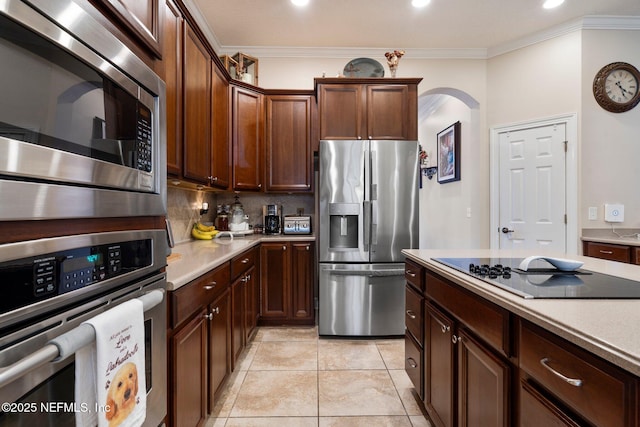 2025 Castle Point Ct, Fleming Island, FL 32003 - kitchen featuring stainless steel appliances, arched walkways, crown molding, light countertops, and tasteful backsplash