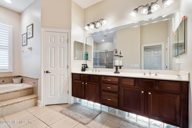 2025 Castle Point Ct, Fleming Island, FL 32003 - full bathroom featuring double vanity, a bath, tile patterned floors, and a stall shower