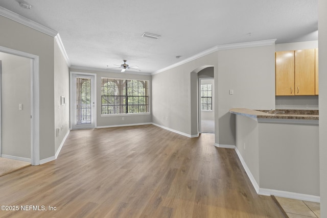 12700 Bartram Park Blvd Unit 1923, Jacksonville, FL 32258 - unfurnished living room featuring ornamental molding, arched walkways, a ceiling fan, healthy amount of natural light, and light wood finished floors
