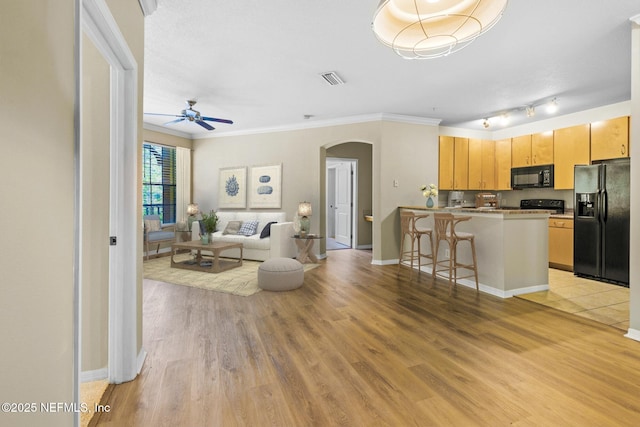 12700 Bartram Park Blvd Unit 1923, Jacksonville, FL 32258 - living area featuring arched walkways, a ceiling fan, light wood-style flooring, and crown molding