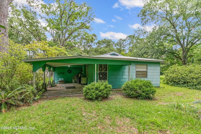 44125 Jarrett Rd, Callahan, FL 32011 - view of front of house featuring a front lawn, an attached carport, and a metal roof