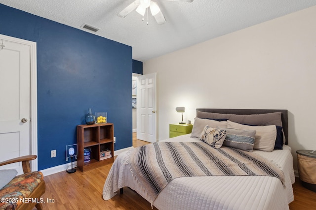 3207 Plum St, Jacksonville, FL 32205 - bedroom with light wood-style flooring, a ceiling fan, and a textured ceiling