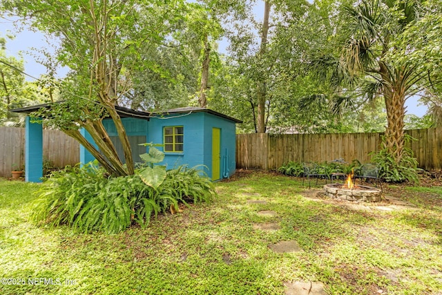 3207 Plum St, Jacksonville, FL 32205 - fenced backyard featuring an outdoor fire pit and an outbuilding