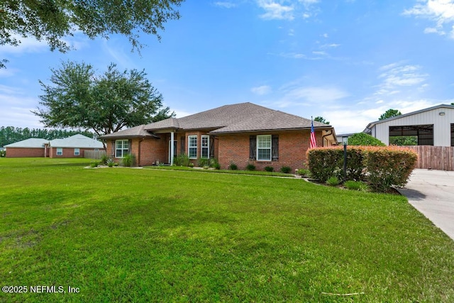 44677 Green Meadows Ln, Callahan, FL 32011 - ranch-style home featuring brick siding, a front yard, and an outdoor structure