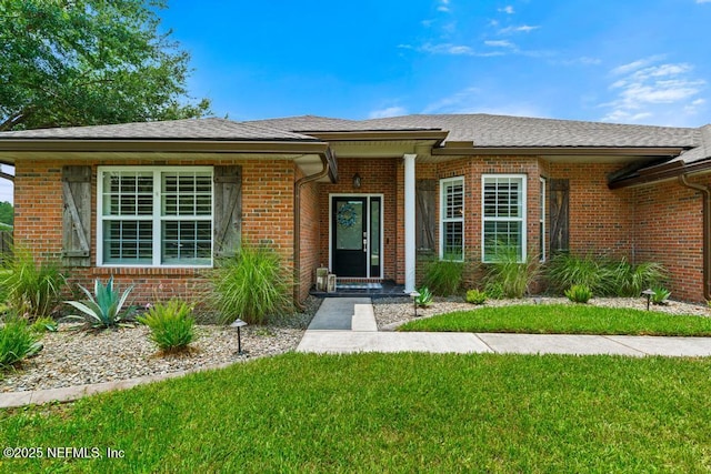 44677 Green Meadows Ln, Callahan, FL 32011 - doorway to property with a lawn, brick siding, and a shingled roof