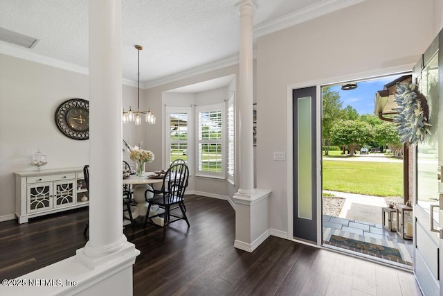 44677 Green Meadows Ln, Callahan, FL 32011 - foyer entrance featuring ornate columns, dark wood-style flooring, ornamental molding, a chandelier, and a textured ceiling
