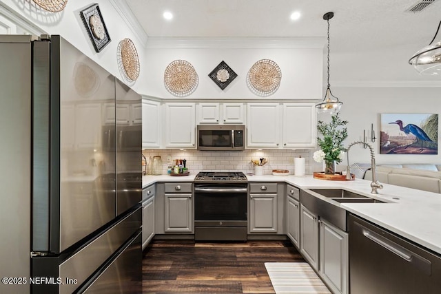 44677 Green Meadows Ln, Callahan, FL 32011 - kitchen featuring stainless steel appliances, gray cabinets, ornamental molding, dark wood finished floors, and light countertops