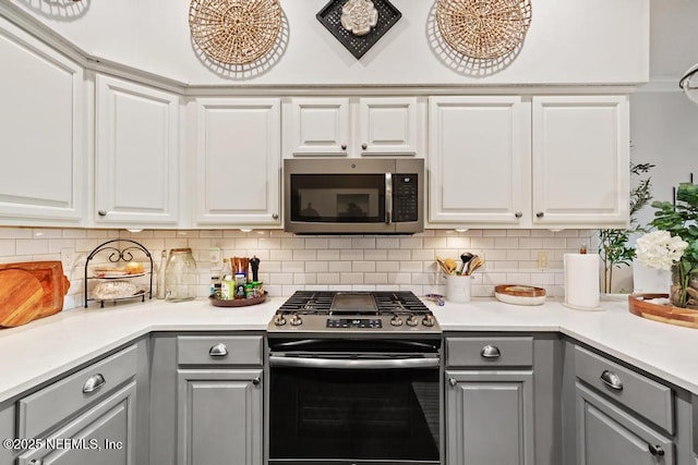44677 Green Meadows Ln, Callahan, FL 32011 - kitchen with stainless steel appliances, gray cabinets, light countertops, and tasteful backsplash