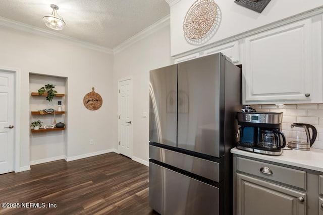 44677 Green Meadows Ln, Callahan, FL 32011 - kitchen with freestanding refrigerator, crown molding, dark wood finished floors, backsplash, and light countertops