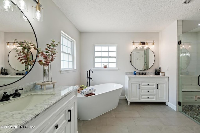 44677 Green Meadows Ln, Callahan, FL 32011 - bathroom featuring a stall shower, a textured ceiling, two vanities, and a freestanding tub