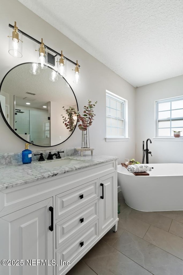 44677 Green Meadows Ln, Callahan, FL 32011 - full bath with a textured ceiling, vanity, a shower stall, a freestanding bath, and tile patterned flooring