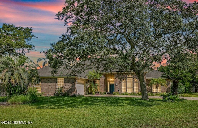 508 Lighthouse Ct, Neptune Beach, FL 32266 - obstructed view of property featuring a garage, a yard, and brick siding
