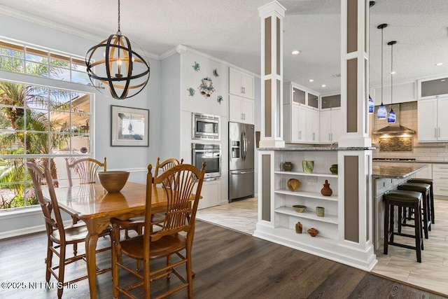508 Lighthouse Ct, Neptune Beach, FL 32266 - dining space featuring ornamental molding, light wood-type flooring, a textured ceiling, and a chandelier