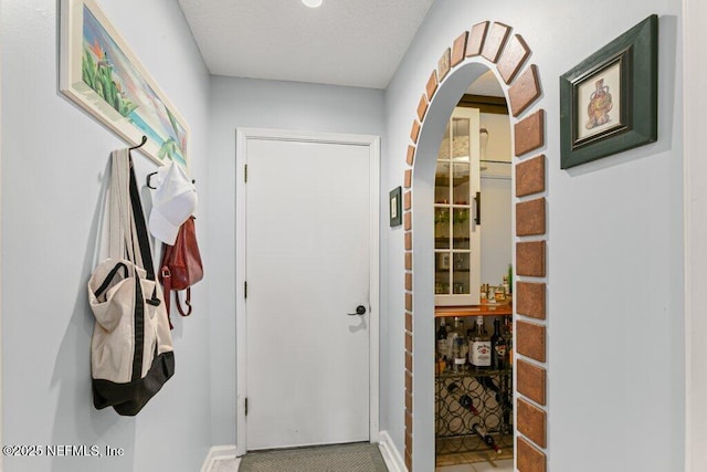 508 Lighthouse Ct, Neptune Beach, FL 32266 - doorway to outside featuring arched walkways and a textured ceiling