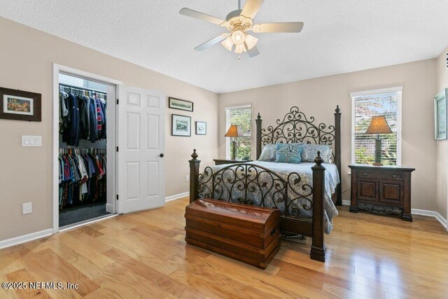 508 Lighthouse Ct, Neptune Beach, FL 32266 - bedroom featuring light wood finished floors, a walk in closet, a closet, a textured ceiling, and ceiling fan