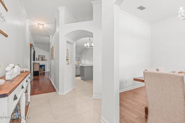 2484 Royal Pointe Dr, Green Cove Springs, FL 32043 - hall featuring arched walkways, ornamental molding, a chandelier, a high ceiling, and light wood-style flooring
